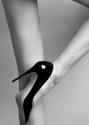Primer plano de la fotografía de una mujer desnuda vista de espaldas, de cintura a tobillo con tacones.