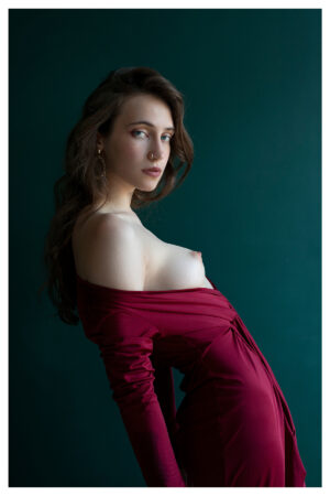 Fotografía de una mujer posando con un vestido color magenta con el pecho al descubierto.