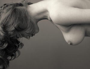 Fotografía en blanco y negro de una mujer desnuda levitando boca abajo.